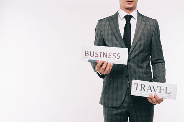 cropped image of businessman holding business and travel newspapers isolated on white - Valokuva, kuva