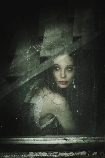 чувственный портрет молодой женщины за старым окном
 - Фото, изображение