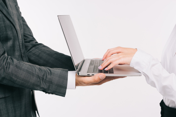 immagine ritagliata di uomo d'affari che tiene il computer portatile per collega isolato su bianco
 - Foto, immagini