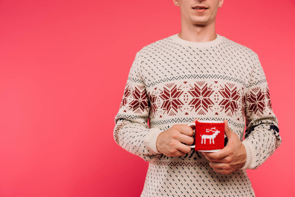 cropped image of man in sweater holding cup with deer silhouette isolated on pink - Photo, Image