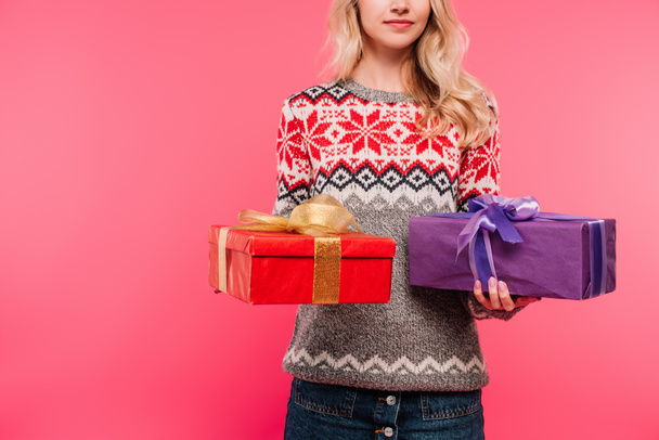 cropped image of girl in sweater holding presents isolated on pink - Фото, изображение