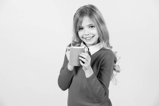Thirst, dehydration concept. Child smile with blue cup on orange background. Girl with long blond hair in red sweater hold mug. Thirst, dehydration concept. Health and healthy drink. - Foto, Imagen