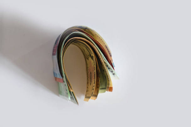 Деньги - доллары, евро и другие валюты лежат на белой поверхности стола
 - Фото, изображение