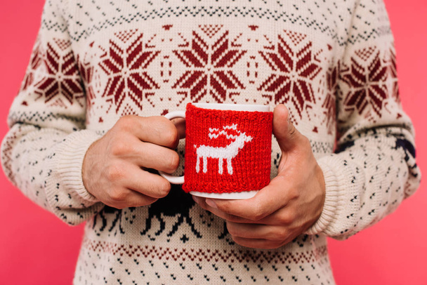 cropped image of man in sweater holding cup with deer silhouette isolated on pink - Φωτογραφία, εικόνα