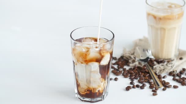 Concepto de café y cócteles. Crema vertida en el café con hielo
 - Metraje, vídeo