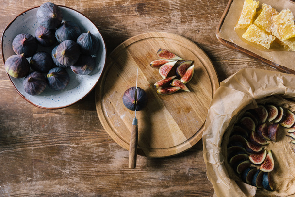pile of figs in bowl and on cutting board on rustic wooden table during pie preparation - Zdjęcie, obraz