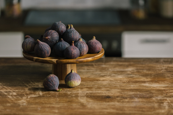 close-up shot of pile of figs on wooden stand and on rustic table - Valokuva, kuva