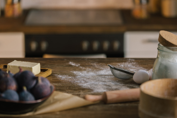 close-up de ingredientes de torta de figo em pé sobre mesa de madeira coberta com farinha
 - Foto, Imagem