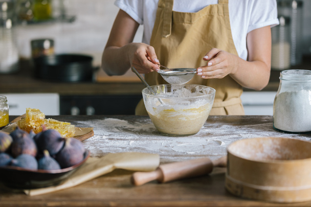обрізаний знімок жінки, що розливає борошно в миску з ситом під час приготування пирога
 - Фото, зображення