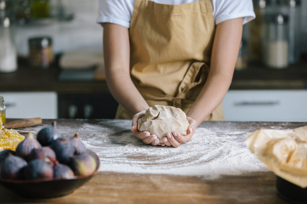 cropped shot of woman holding dough for pie on rustic wooden table - 写真・画像
