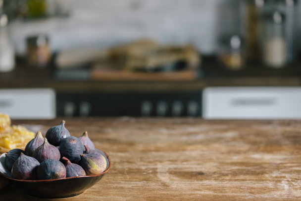 close-up shot of bowl with ripe figs standing on rustic wooden table - 写真・画像