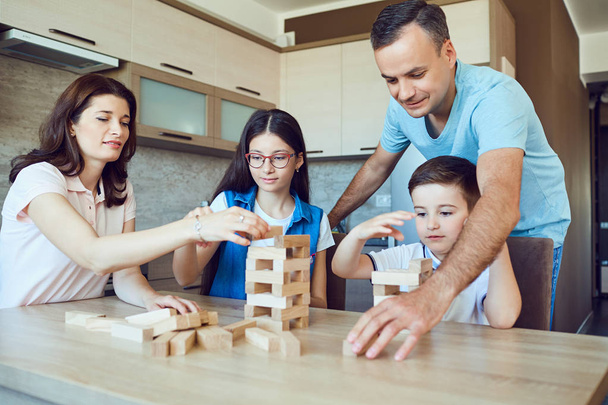 A cheerful family plays board games at home.  - Photo, Image