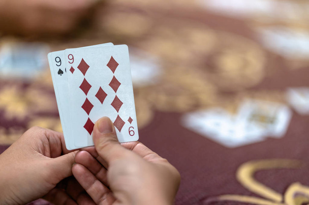Reaw вид крупним планом азіатська жінка грає в карти з грошима на столі над килимом, ризик і удача концепції гри
 - Фото, зображення