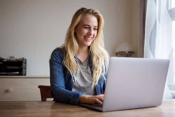 Portrét šťastné mladé blond ženy doma pomocí přenosného počítače - Fotografie, Obrázek