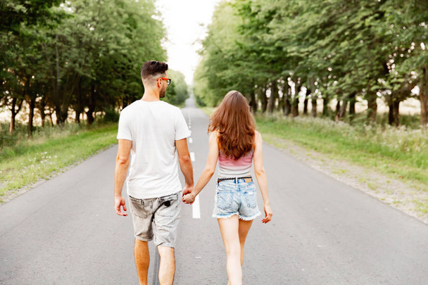 Young couple going on the road. natural background. solar morning - Фото, изображение