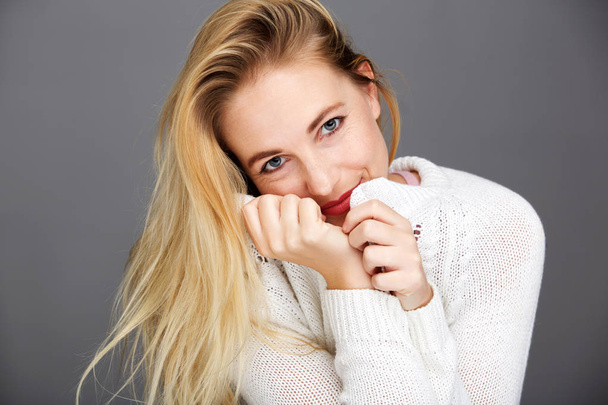Portret uśmiechnięta młoda blond kobieta z białym sweter z bliska - Zdjęcie, obraz