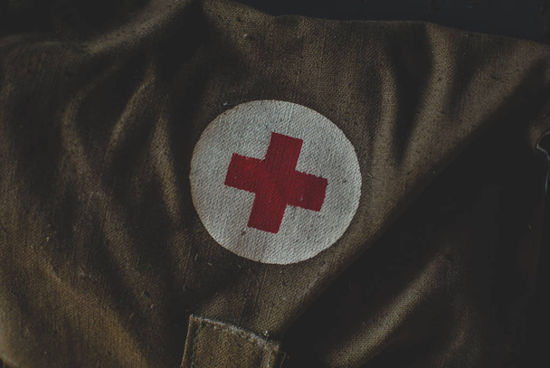 Kit di pronto soccorso militare e di emergenza nel magazzino. Segno medico simbolo della croce rossa sulla borsa verde
 - Foto, immagini