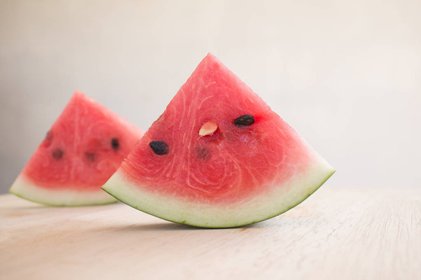 Slices of watermelon on wooden desk background - 写真・画像