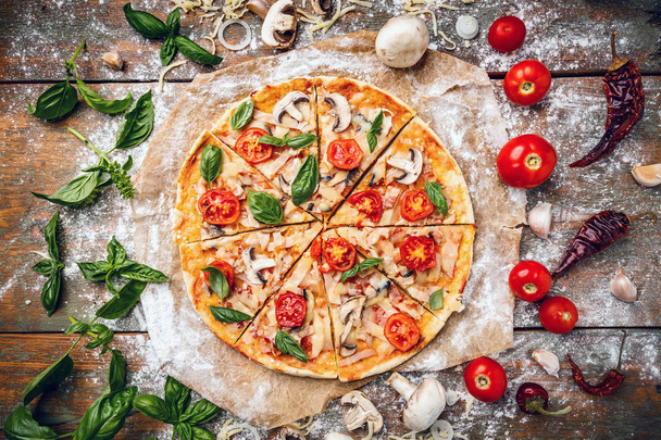 Flat lay of Italian pizza on wooden background and various ingredients - Foto, Imagem