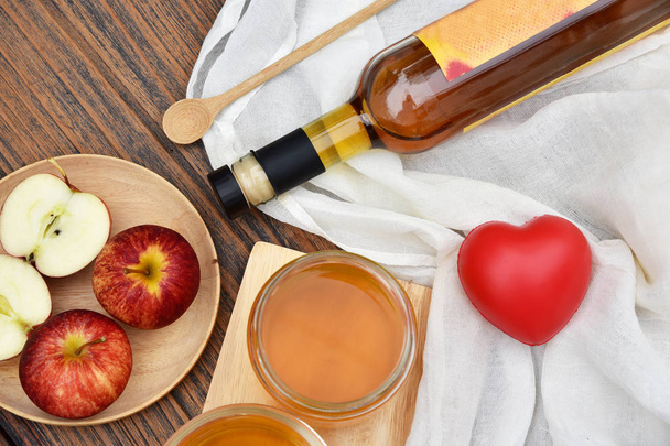 Jablečný ocet na dřevěné desce, Kombucha čaj s plátky jablek, zdravé probiotické nutriční nápoj pro dobrou rovnováhu trávicí systém. - Fotografie, Obrázek