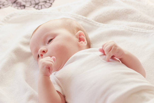 Smiling baby on the bed, indoors, soft focus background - Foto, imagen