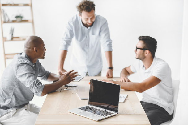 hommes d'affaires multiethniques discutant d'une nouvelle idée d'entreprise sur le lieu de travail
 - Photo, image