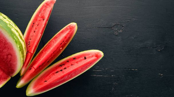 Fresh watermelon Fruits. Melon. On a black wooden background. Free space for text. Top view. - Fotoğraf, Görsel