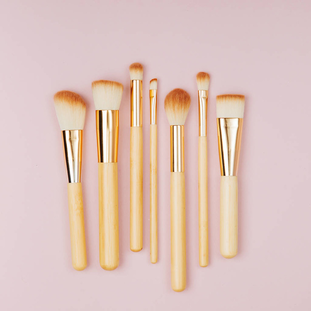 Fashion various makeup brushes on a pastel pink background. Flat lay, top view - Foto, imagen