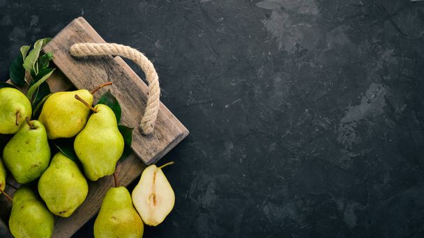 Fresh pears on a black stone table. Fruits. Free space for text. Top view. - Foto, immagini