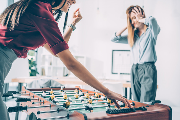 businesswomen playing table football in modern office - 写真・画像