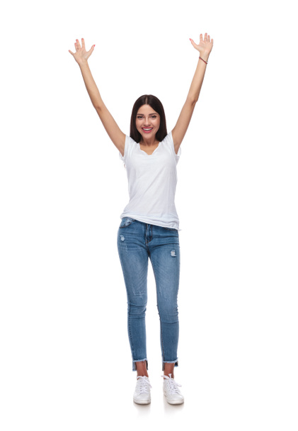 pretty casual woman celebrating with hands in the air while standing on white background, full body picture - Photo, image