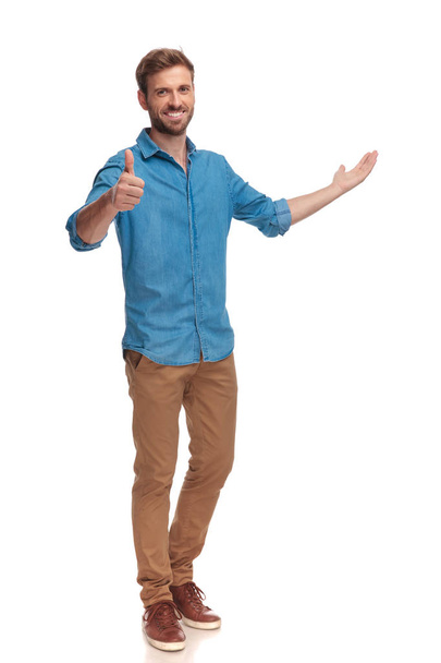 full body picture of a casual man presenting and making the ok sign on white background - Fotó, kép