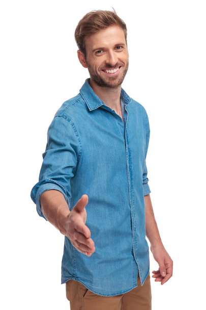 happy casual man welcomes with a handshake on white background - Zdjęcie, obraz