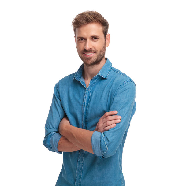 young smiling casual man standing with hands crossed on white background - Photo, Image