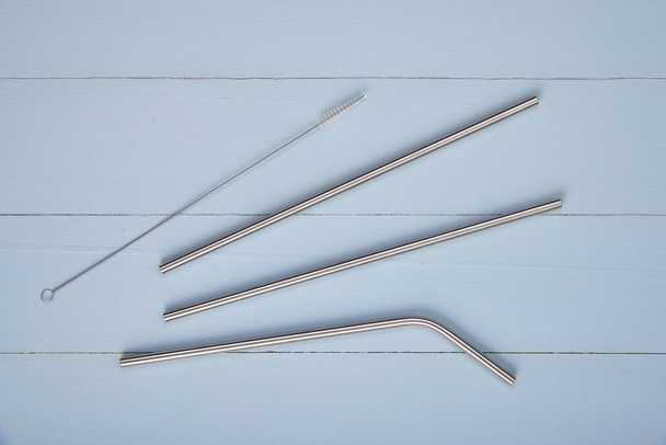 reusable straight and bent stainless steel straws o n a table - Foto, imagen
