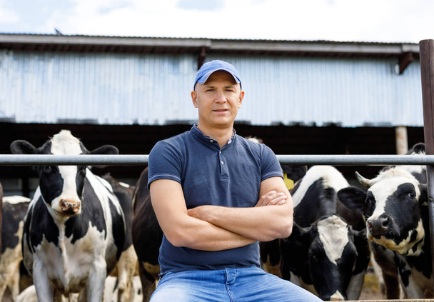 Bauer auf Bauernhof mit Milchkühen - Foto, Bild