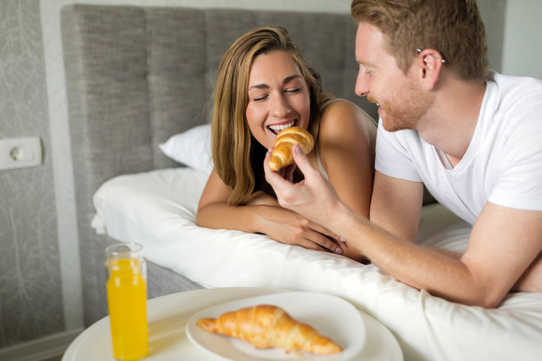 Happy couple in love enjoying breakfast in bed - Φωτογραφία, εικόνα