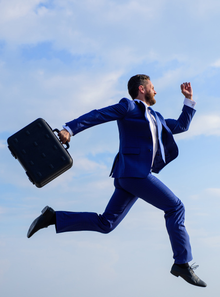 Businessman formal suit make effort to succeed. Success in business demands supernatural efforts from entrepreneur personality. Businessman with briefcase jump high motion forward. Supernatural power - Foto, afbeelding