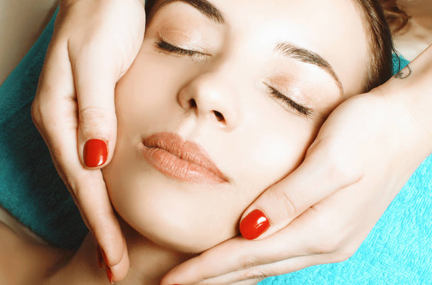 beautiful and young girl doing anti-aging facial massage - 写真・画像