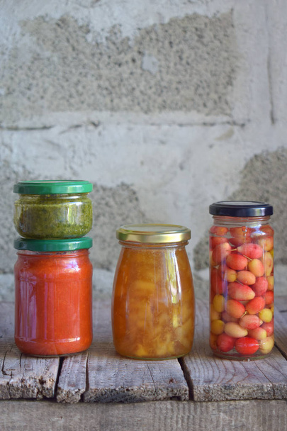 Variedad de alimentos conservados en frascos de vidrio: encurtidos, mermelada, mermelada, salsas, ketchup. Conservación de verduras y frutas. Comida fermentada. Enlatado de otoño. Conservación de la cosecha
 - Foto, Imagen