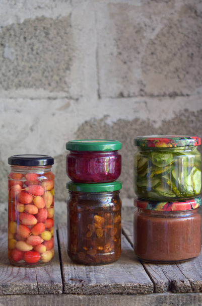 Variedad de alimentos conservados en frascos de vidrio: encurtidos, mermelada, mermelada, salsas, ketchup. Conservación de verduras y frutas. Comida fermentada. Enlatado de otoño. Conservación de la cosecha
 - Foto, Imagen