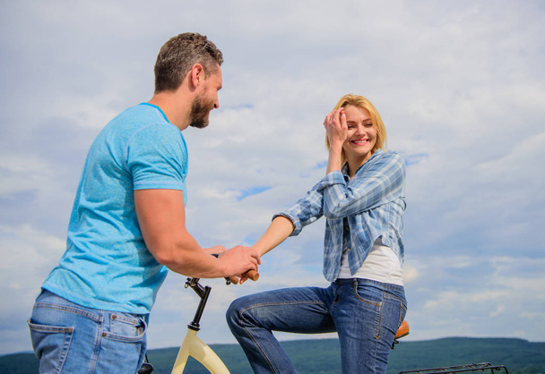 Rolling romance or bike date. asual acquaintance concept. Man with beard and shy blonde girl on first date. Woman feels shy in company with attractive macho. Couple just meet to hang out together - Фото, зображення