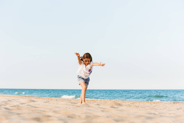 Image of young cute little girl having fun together outdoors at the beach. - Photo, Image