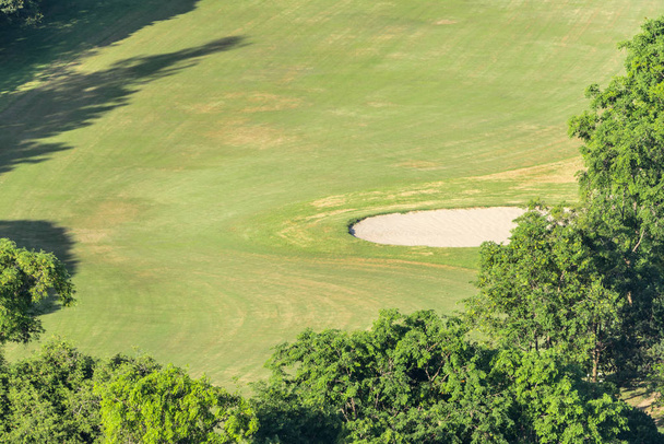 Krajobraz w widok na pole golfowe dla golfa z trawa zielony pole, putting green i bunkry i Natura Las - Zdjęcie, obraz