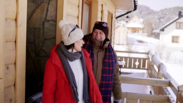 fröhliches Paar verlässt ein Chalet in den Bergen - Filmmaterial, Video