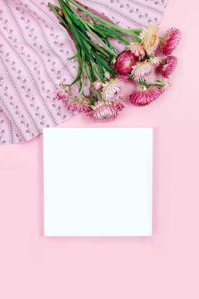 Flores rosadas otoñales sobre fondo rosa con tarjeta blanca. Vista superior del espacio de copia de la tarjeta de felicitación
. - Foto, imagen