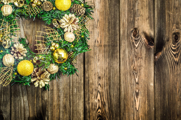 Adventní vánoční věnec na dřevěné pozadí, dekorace zlatem ozdoby na zavěšení na dveře - Fotografie, Obrázek