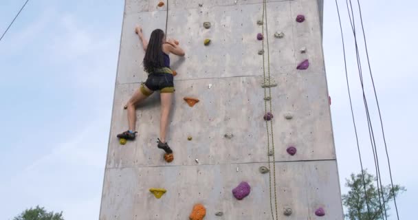Escalador de rocas mujer haciendo ejercicio en la pared del gimnasio de escalada al aire libre
 - Metraje, vídeo