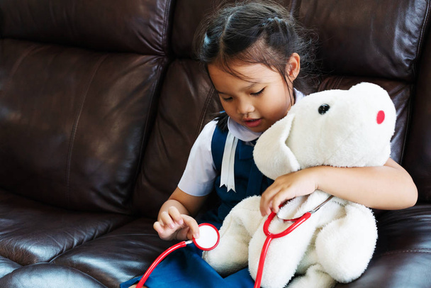 La bambina sorride e gioca al dottore con lo stetoscopio. Concetto di assistenza sanitaria e infantile
. - Foto, immagini
