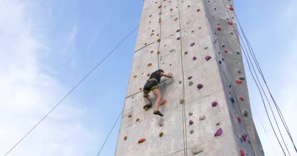 Ογκόλιθος ορειβάτης γυναίκα που ασκούν σε υπαίθριο τοίχο αναρρίχησης γυμναστήριο - Πλάνα, βίντεο
